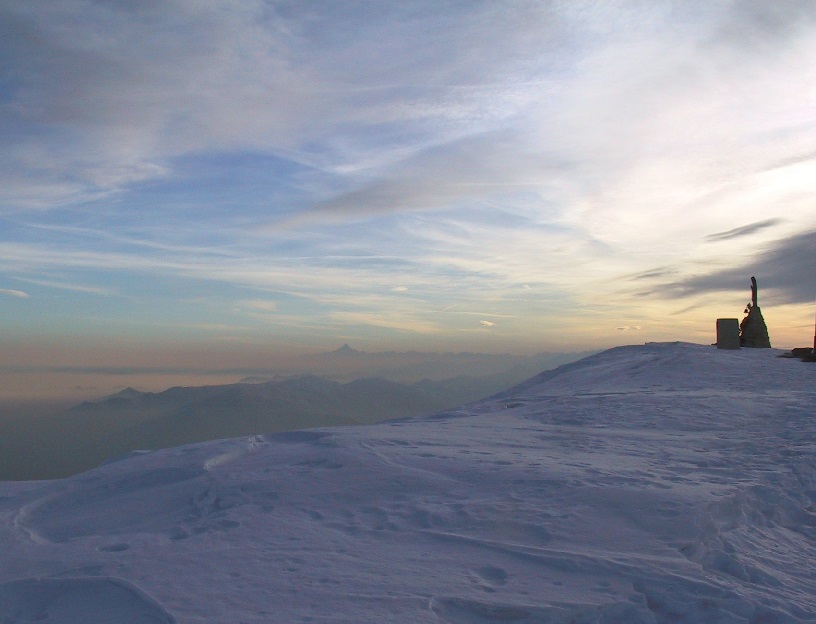 La vetta del Monte Soglio (1970 m) d'inverno, con il Monviso sullo sfondo